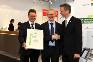 Zertifikatsübergabe auf der Dach+Holz in Köln am 19.01.2014: Lothar Moll (links), Gründer und Geschäftsführer MOLL pro clima, Uwe Bartholomäi, Geschäftsführer MOLL pro clima und Peter Bachmann, Gründer und Geschäftsführer Sentinel Haus Institut.  