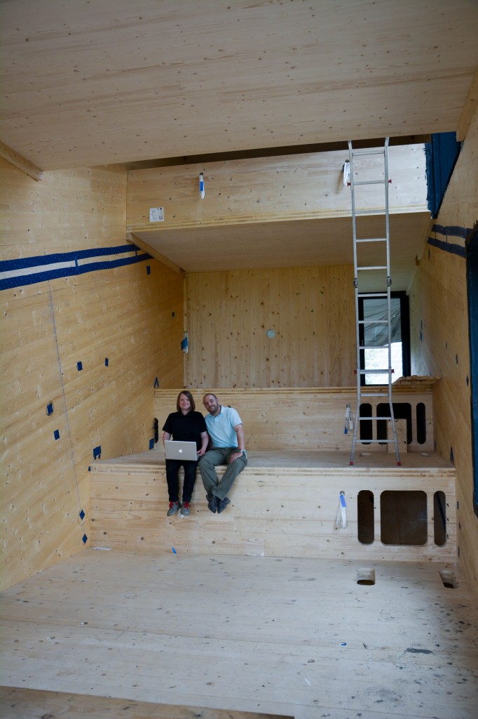 Die Architektin, Innenarchitektin und Tischlerin Henrike Gänß arbeitet seit zwei Jahren an dem Mini-Max Projekt. Unterstützt wird sie von ihrem Projektpartner, dem Wirtschaftsingenieur Marc Rother. Mit ihrem Büro für Konzeption und Gestaltung, HOCH5, wollen die beiden ihre Visionen aus dem Studium in der Realität umsetzen. „Zum einen wird Wohnraum immer knapper, zum Beispiel in den Großstädten. Andererseits wird Wohnraum auch immer aufgeblasener und minderwertiger. Das hat zur Folge, dass die Menschen auch immer mehr Wohngiften ausgesetzt sind. Wir wollen zeigen, dass es ein Ausweg gibt. Das Mini-Max-Projekt beweist, dass man Raum reduzieren kann, ohne dass man das Gefühl von Verzicht hat“, sagt Henrike Gänß. Mini-Max ist noch in der Bauphase – im Juli 2014 haben Gänß und Rother den Rohbau abgeschlossen. Hier sitzen die Ingenieure in dem künftigen Einraum bei einer Baubesprechung. Von der Fläche her umfasst diese Funktionszone neun Quadratmeter.